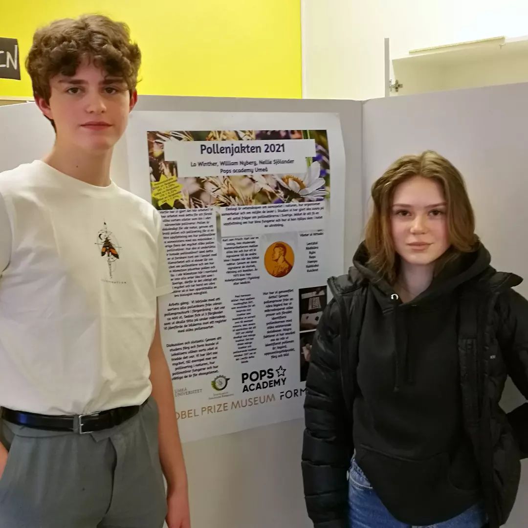 Två elever står framför en poster med elevernas resultat av projektet Pollenjakten 2021.