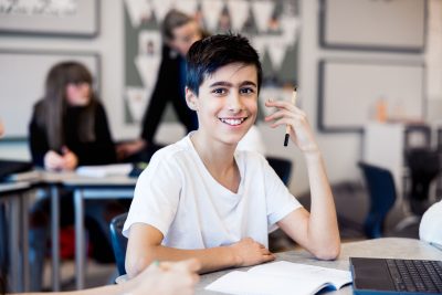 Elev på Pops Academy sitter vid en skolbänk i klassrummet.