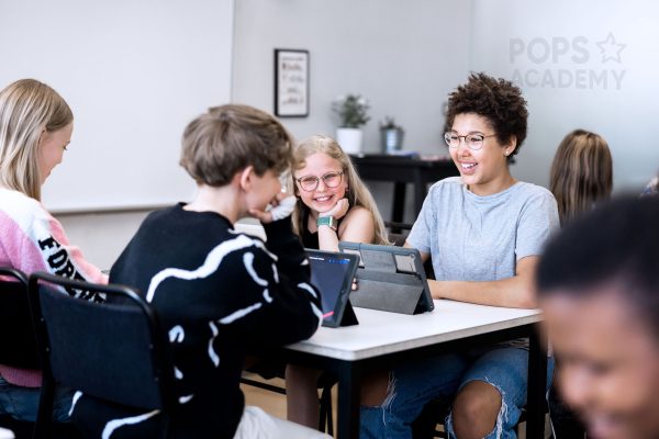 Fyra elever på Pops Academy jobbar tillsammans i klassrummet.