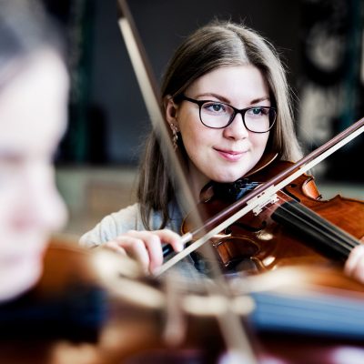 Två elever på Pops Academy spelar fiol tillsammans.