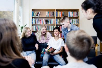 Elever på Pops Academy sitter i skolbiblioteket.