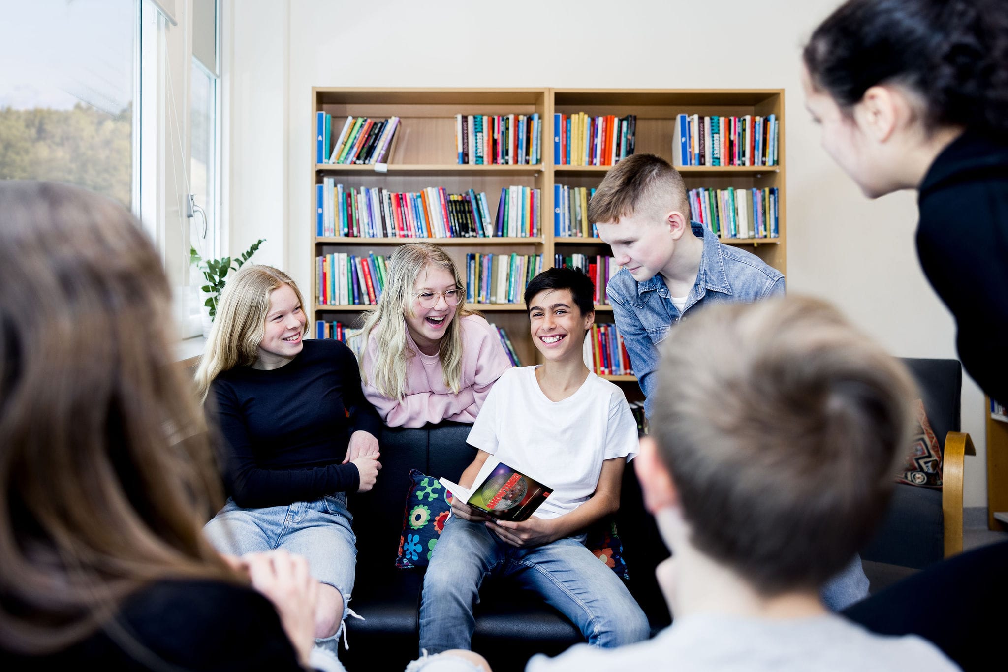 Elever på Pops Academy sitter i skolbiblioteket.