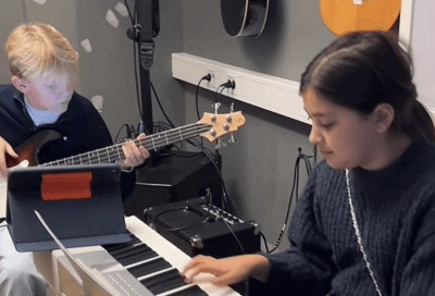 Två elever övar på bas och keyboard.