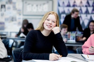 Elev i klassrummet som lutar huvudet i handen.
