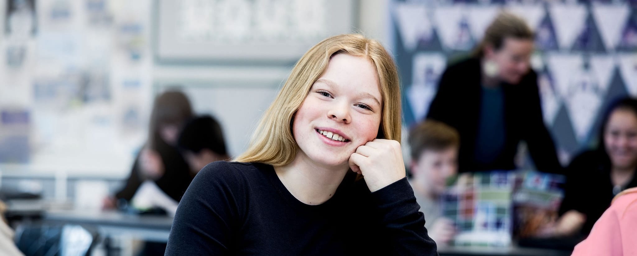 Elev i klassrummet som lutar huvudet i handen.