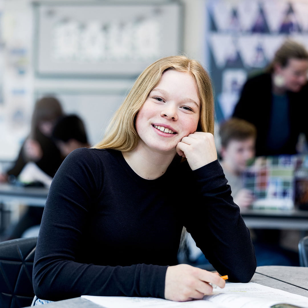 Elev på Pops Academy sitter vid en skolbänk i klassrummet.