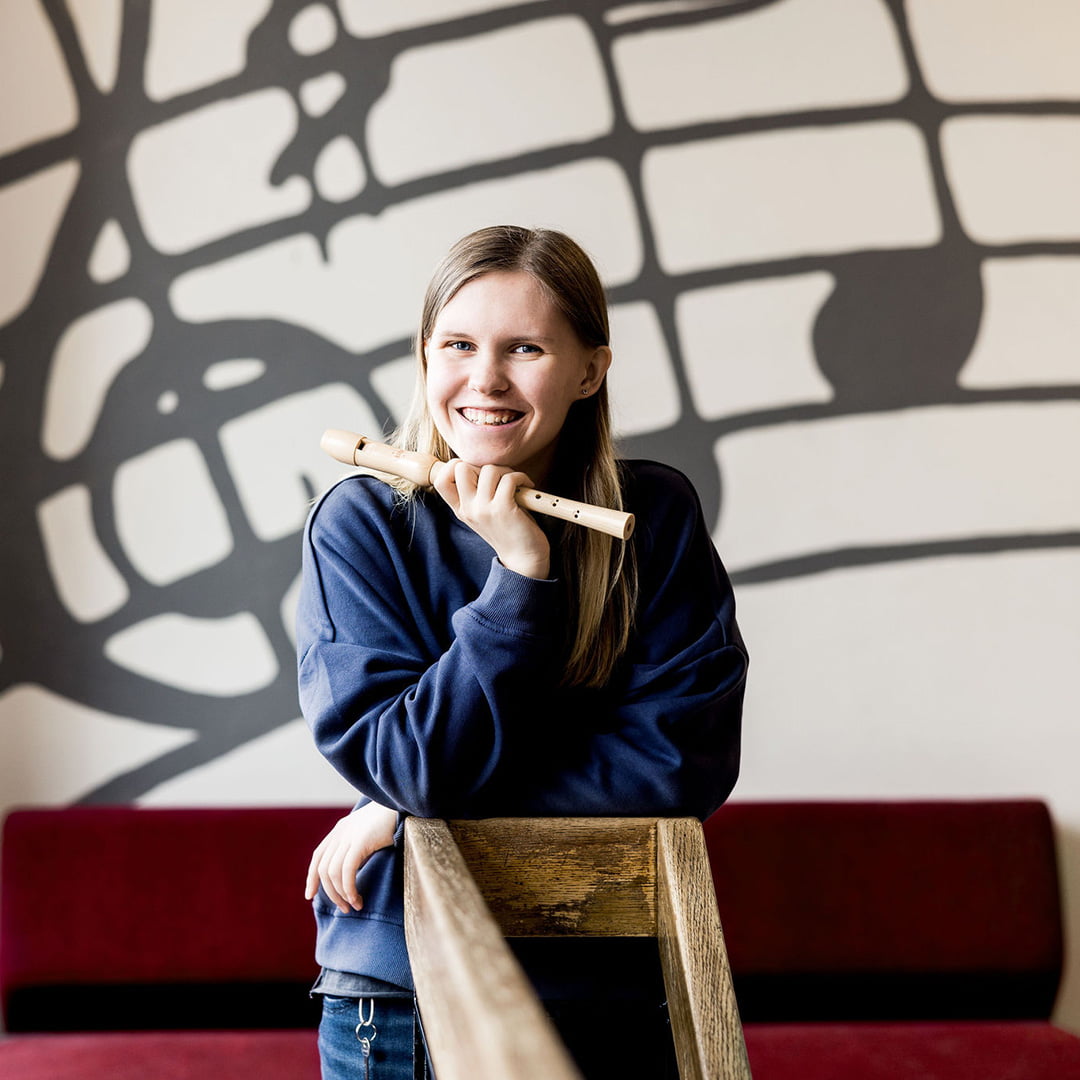 Elev på Pops Academy står med sin flöjt.