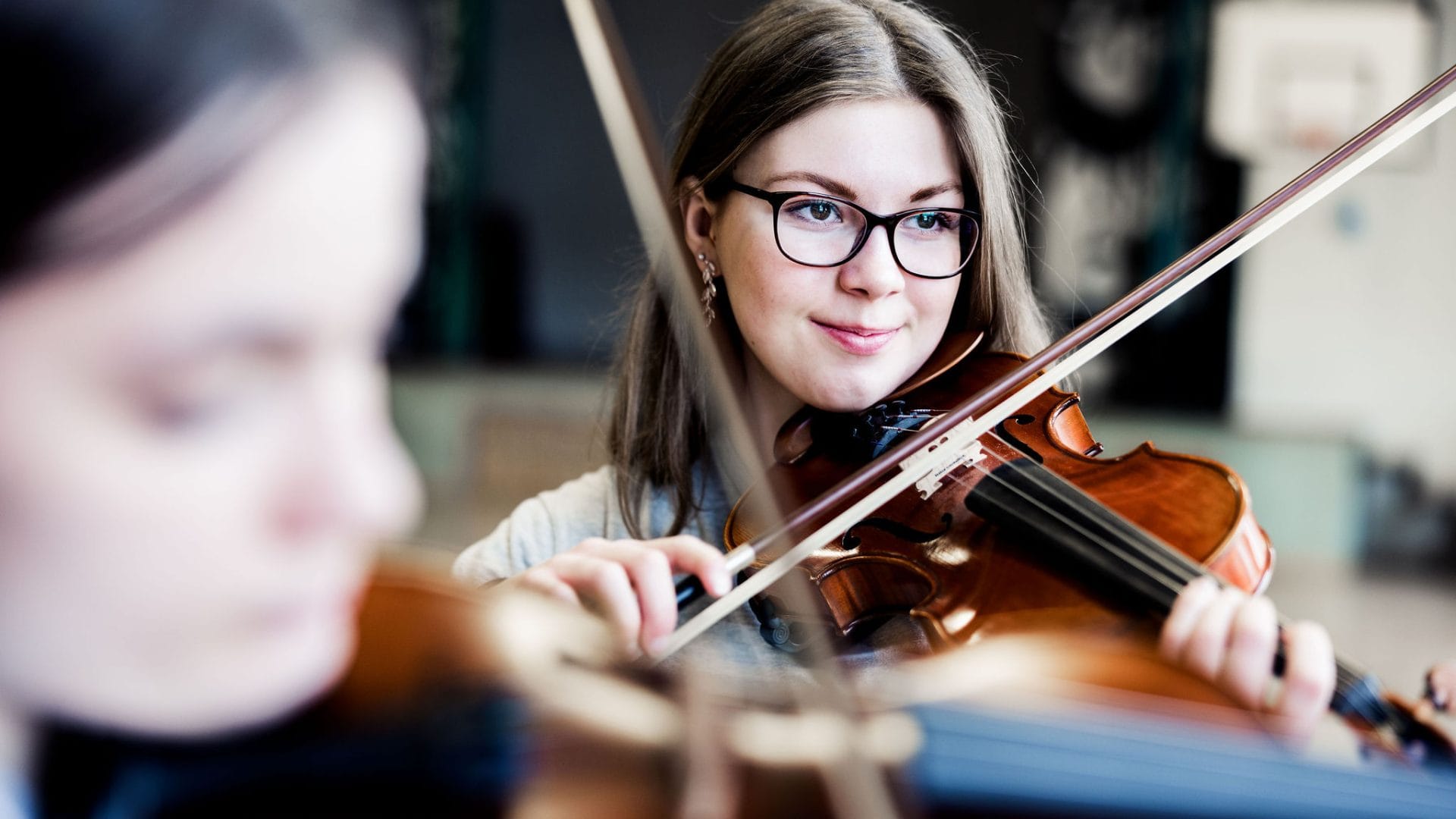 Två elever på Pops Academy spelar fiol tillsammans.