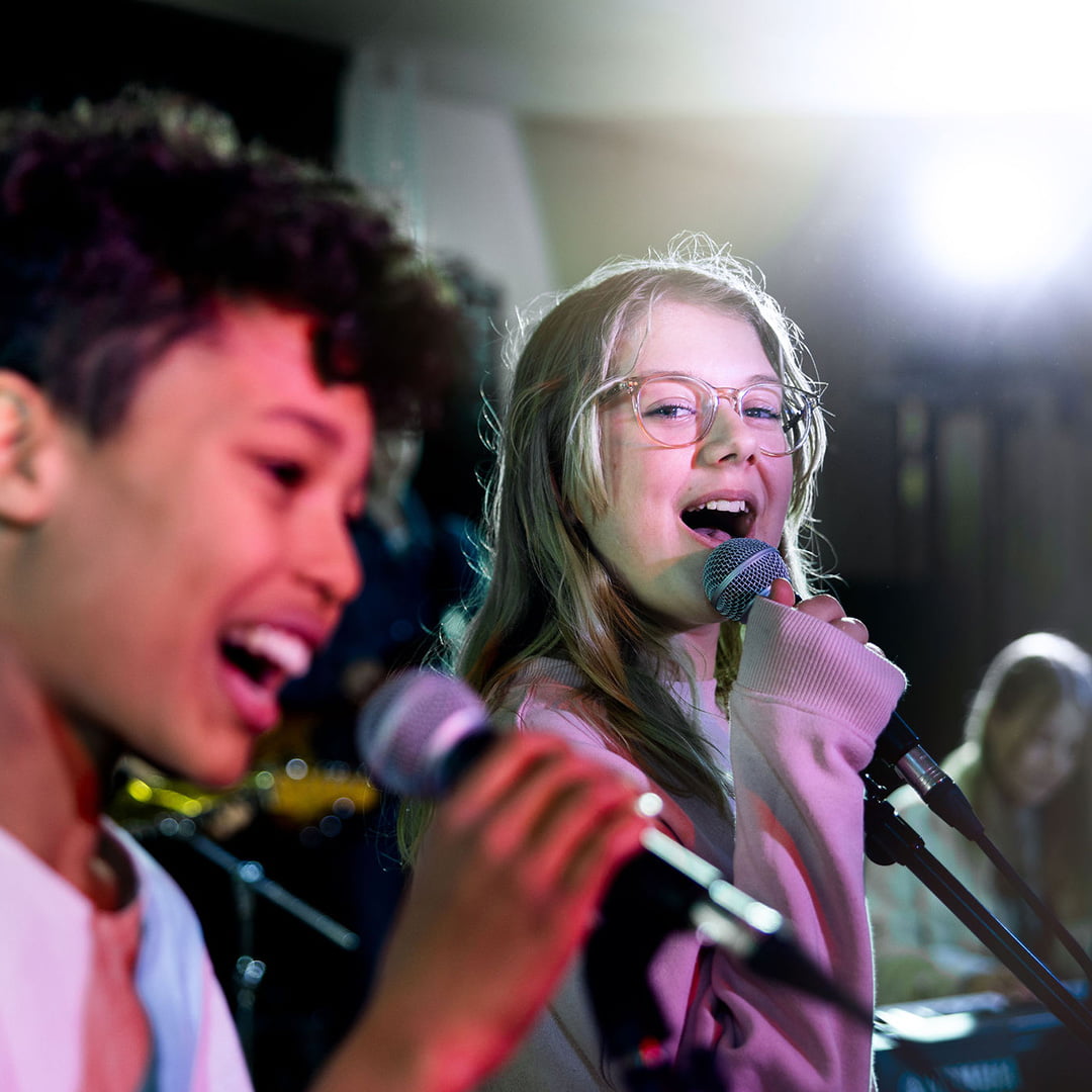 Elever på Pops Academy sjunger tillsammans på scen.