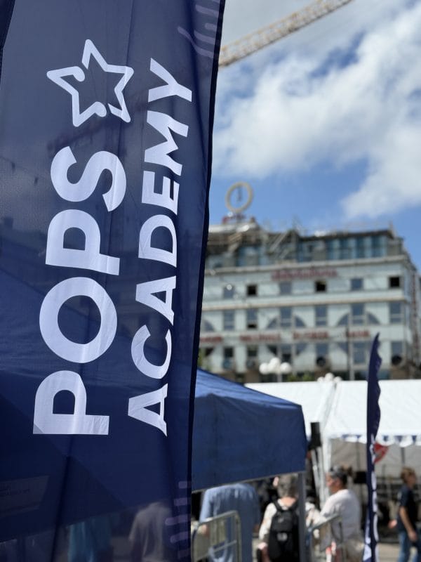 Flagga med Pops Academys logga på Medborgarplatsen under Popsfestivalen 2026.