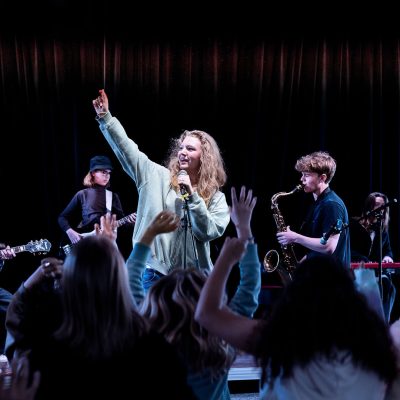 Ett band spelar och sjunger på scen.