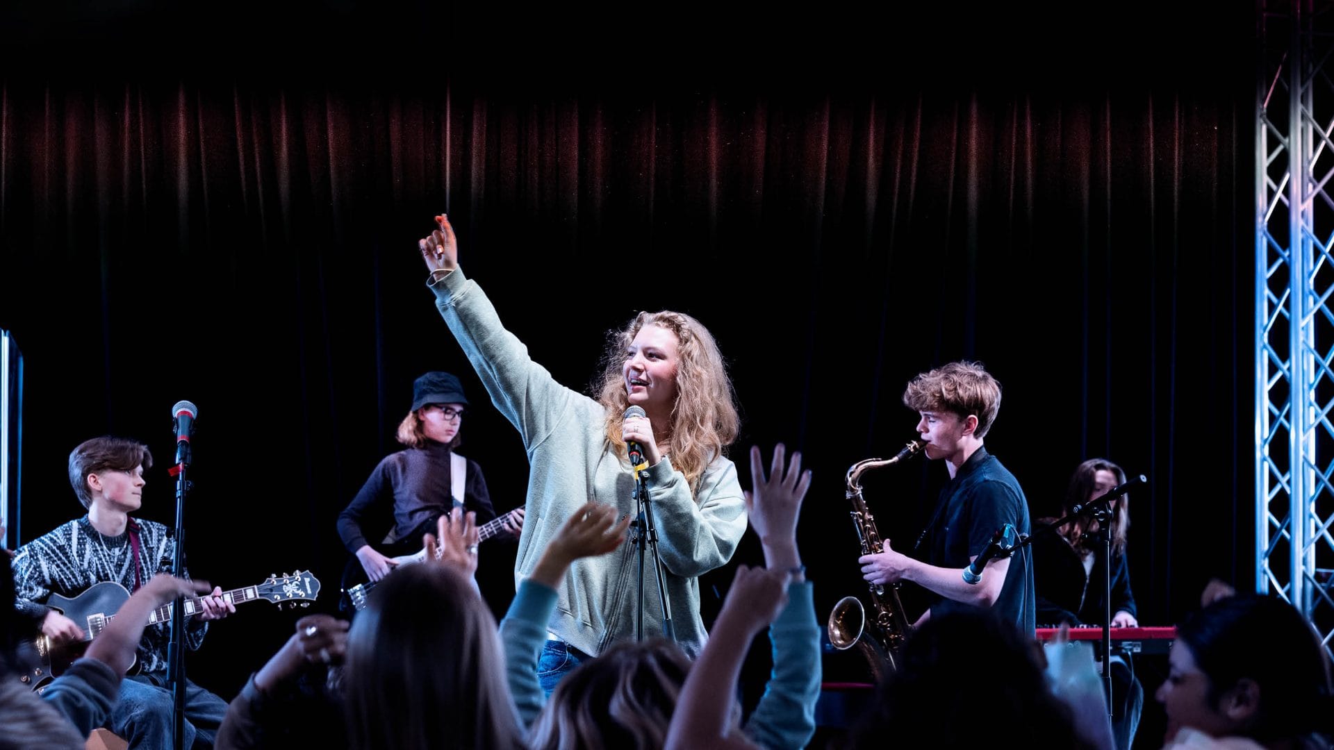 Elever som sjunger och spelar instrument på scen