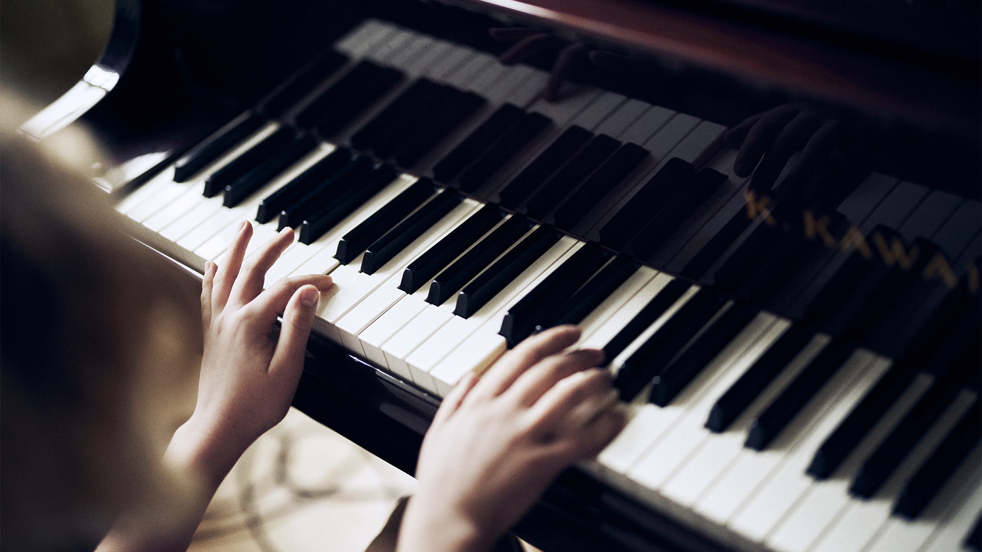 Två händer spelar följsamt på ett piano